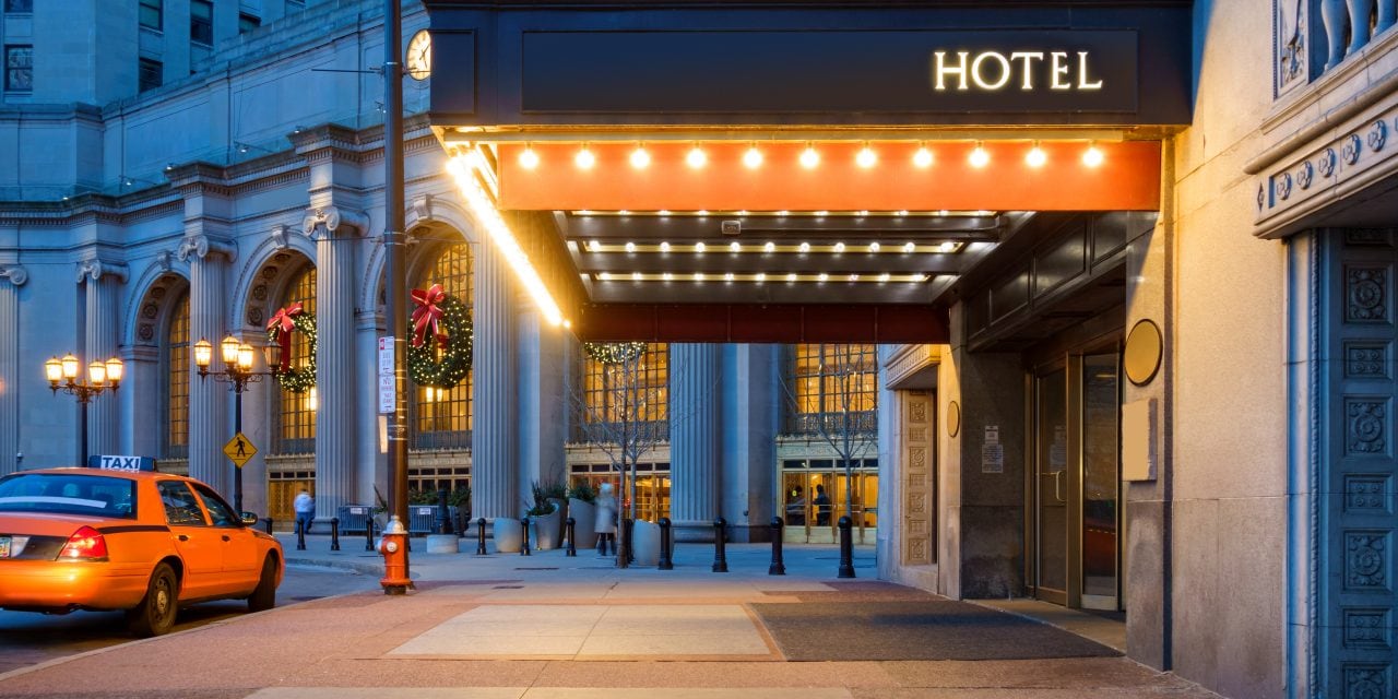 Photo of a hotel entrance and a waiting taxi cab in downtown Cleveland during the winter holidays.